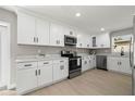 Modern kitchen features white cabinetry, stainless steel appliances, and light countertops at 818 S Main St, Brooksville, FL 34601