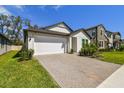 Charming single-Gathering home with a two-car garage and brick-paved driveway at 9802 Carabiner Way, Land O Lakes, FL 34637