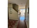 Hallway with hardwood floors leads to a bright living area and stairs at 10002 Bradwell Pl, Tampa, FL 33626