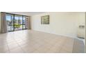 A sunlit living room with tile flooring and a sliding glass door that open to balcony at 14130 Rosemary Ln # 5206, Largo, FL 33774