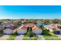 Stunning aerial view of a single-story home, community, and tranquil lake at 16145 Amethyst Key Dr, Wimauma, FL 33598