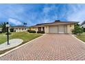 Charming home featuring a well-manicured lawn and a brick driveway leading to a two-car garage at 1710 New Bedford Dr, Sun City Center, FL 33573