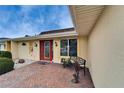 Charming front entry with brickwork, decorative door, manicured shrubs, and an inviting bench at 1710 New Bedford Dr, Sun City Center, FL 33573