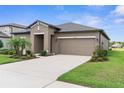 A well-maintained home with a spacious two-car garage and a neatly landscaped front yard at 18414 Malinche Loop, Spring Hill, FL 34610