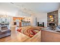 Open-concept living room with hardwood floors, a modern fireplace, and an adjacent kitchen and dining area at 217 2Nd Sw St, Largo, FL 33770