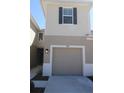 Attached single-car garage and a walkway leading to the front door of the townhome at 3032 Inlet Breeze Way, Holiday, FL 34691