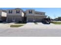 Street view of a townhome with attached garages and well-manicured landscaping at 3032 Inlet Breeze Way, Holiday, FL 34691