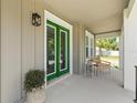 Cozy front porch with green doors and a seating area for relaxation and enjoying the outdoors at 410 W Paris St, Tampa, FL 33604