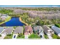 An aerial view showcases the property's proximity to a serene lake and lush greenery at 4152 Marchmont Blvd, Land O Lakes, FL 34638