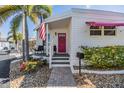 Inviting front porch with an American flag and beautiful landscaping leading to the pink front door at 4851 W Gandy Blvd # B3L35, Tampa, FL 33611