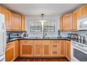 Well-lit kitchen featuring wood cabinets, sleek black countertops, and modern appliances at 4851 W Gandy Blvd # B3L35, Tampa, FL 33611