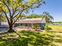 Beautiful home surrounded by mature trees, lush lawn, and views of the nearby lake at 498 Lakewood Dr, Brandon, FL 33510