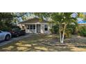 Charming one-story home featuring a manicured front lawn with vibrant palm trees at 522 Mclennan St, Clearwater, FL 33756