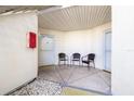 This condo has a covered entrance featuring a seating area with chairs and a white-colored door with a screen at 6061 Bahia Del Mar Blvd # 112, St Petersburg, FL 33715