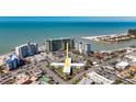 An aerial daytime shot shows the property amidst nearby beaches, a waterway, and other residential buildings at 7050 Sunset Way # 26, St Pete Beach, FL 33706