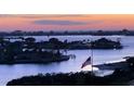 Beautiful scenic water view featuring islands, homes, and an American flag at dusk at 100 Bluff View Dr # 417A, Belleair Bluffs, FL 33770