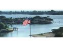 Picturesque waterfront view highlighting an American flag, surrounding homes, and the intracoastal waterway at 100 Bluff View Dr # 417A, Belleair Bluffs, FL 33770