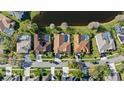 Aerial view showcasing the homes, lush lawns, and mature landscaping in the community bordering a pond at 10561 Greencrest Dr, Tampa, FL 33626