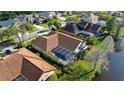 Aerial view of a home with a screened-in pool and lush backyard with a pond at 10561 Greencrest Dr, Tampa, FL 33626