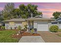 Charming home at dusk showcasing manicured landscaping adding to its curb appeal at 1489 Dundee Dr, Palm Harbor, FL 34684