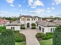 Stately two-story house with symmetrical landscaping, brick driveway, and attached two-car garage at 16312 Palmettoglen Ct, Lithia, FL 33547