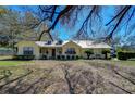 Charming yellow home featuring a metal roof, well-manicured lawn, and inviting front porch at 16349 Spring Valley Rd, Dade City, FL 33523
