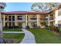 Attractive condo building featuring a red terracotta roof, neutral paint, and manicured landscaping at 1712 Hammock Pine Blvd # 1712, Clearwater, FL 33761