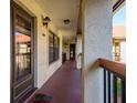 Exterior hallway with view of the front door, stucco walls, and neutral colored concrete at 1712 Hammock Pine Blvd # 1712, Clearwater, FL 33761