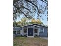 Inviting single-Gathering home with a well-manicured lawn, and a blue painted front door at 1743 Maryland Ne Ave, St Petersburg, FL 33703