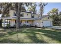 Charming two-story home with a welcoming front porch, well-manicured lawn, and attached two-car garage at 18715 Lakeshore Dr, Lutz, FL 33549
