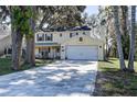 Charming two-story home with a well-maintained lawn and a large driveway leading to a two-car garage at 18715 Lakeshore Dr, Lutz, FL 33549