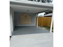 The covered parking area has grey flooring, white support beams, and an ornate concrete slab on the back wall at 2418 S Ramona Cir, Tampa, FL 33612