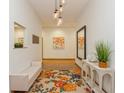 Bright entryway with a floral rug, modern lighting, bench seating, and decorative artwork enhancing the welcoming space at 2660 Powell Ln, Tarpon Springs, FL 34688