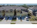 Aerial view of well-maintained townhomes featuring two-car garages, complementing landscaping, and a well kept roof at 3060 Inlet Breeze Way, Holiday, FL 34691