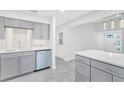 Open concept kitchen with stainless steel appliances, quartz countertops, and stylish grey cabinetry at 3184 Cypress Green Dr, Palm Harbor, FL 34684