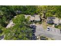 Aerial view shows the property surrounded by mature trees and includes parking and neighboring building at 4031 Bluff Oak Ct, Palm Harbor, FL 34684
