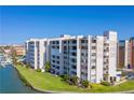 Lovely condo complex on waterfront with lush lawn and dock access under a clear blue sky at 450 Treasure Island Cswy # 507, Treasure Island, FL 33706