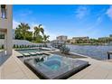 Inviting waterside hot tub and pool area with sleek tiling, professional landscaping, and boat dock at 48 Sandpiper Rd, Tampa, FL 33609