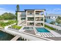 Stunning waterfront home with an infinity pool, integrated hot tub, and covered outdoor seating areas at 48 Sandpiper Rd, Tampa, FL 33609