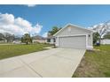 Home exterior with a two-car garage, healthy green lawn, and manicured landscaping at 5134 Jenson Ave, Spring Hill, FL 34608