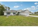 Home exterior with a two-car garage, healthy green lawn, and landscaped yard at 5134 Jenson Ave, Spring Hill, FL 34608