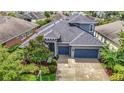 Aerial view of a home with a beautiful roof, a driveway and surrounded by lush landscaping at 6527 Mayport Dr, Apollo Beach, FL 33572