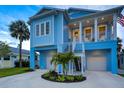 Stunning elevated two-story home with a spacious porch, staircase, and meticulously landscaped front yard at 720 Bay Esplanade, Clearwater Beach, FL 33767
