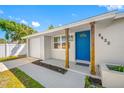 Front entrance with blue door, covered porch, and adjacent garage at 8422 85Th Ct, Seminole, FL 33777