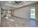Open-concept living room and kitchen with abundant natural light and wood-style tile flooring at 8563 Starlight Loop, Parrish, FL 34219