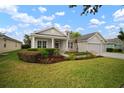 Charming single story home with a beautifully landscaped front yard and welcoming front porch with columns at 12339 Silton Peace Dr, Riverview, FL 33579