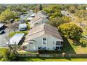 An aerial view of townhomes shows the property's layout, landscaping, and parking, nestled in a green, tree-lined community at 12411 Eagleswood Dr # B, Hudson, FL 34667