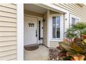 Inviting front entrance with decorative door, 'Welcome' sign, siding, and colorful foliage at 12411 Eagleswood Dr # B, Hudson, FL 34667