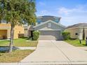 Charming two-story home with a well-maintained lawn and a spacious driveway at 14422 Scottburgh Glen Dr, Wimauma, FL 33598