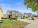 Inviting two-story home with lush green lawn, complemented by a wide driveway at 14422 Scottburgh Glen Dr, Wimauma, FL 33598